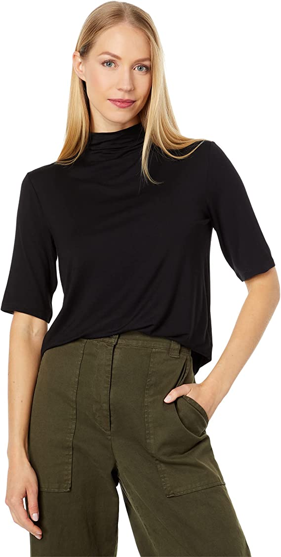 Dark Academia Top worn by Blonde Model from designer Vince With Mock Neck and Half Length Sleeves Paired with Green Pants